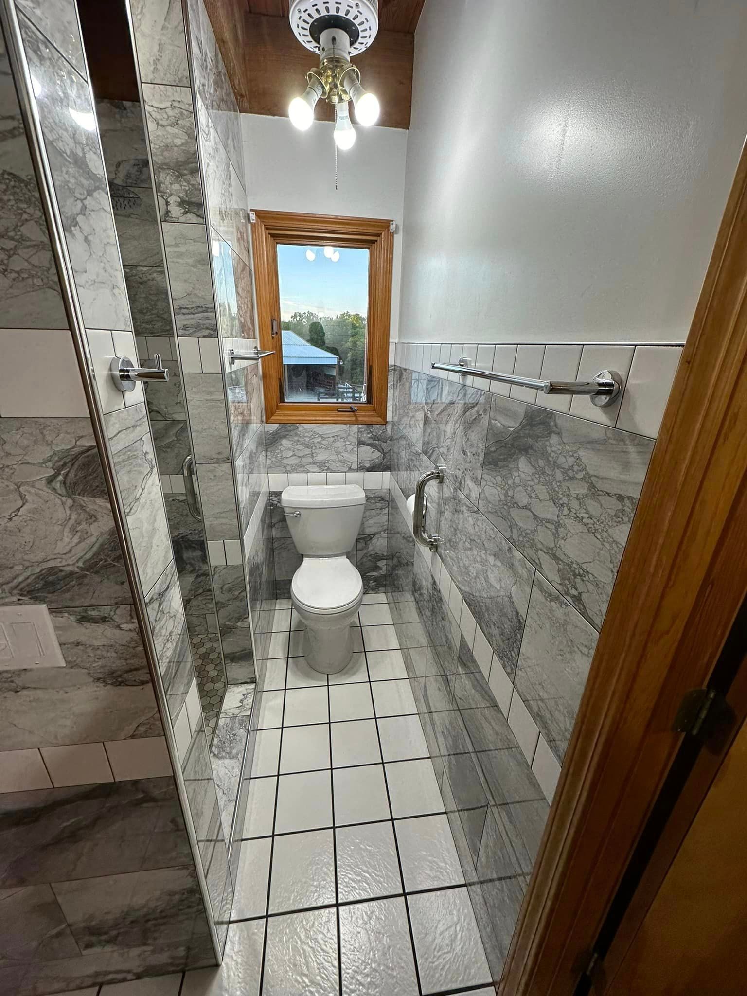 A bathroom with a toilet and a window.