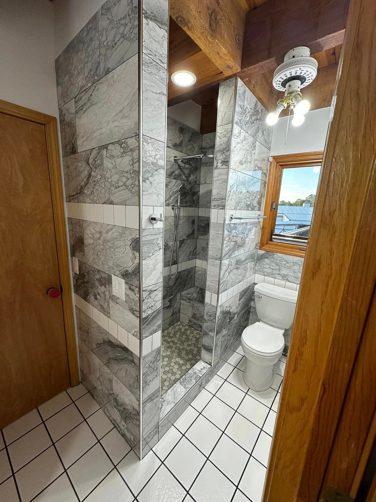 A bathroom with a walk in shower and a toilet.