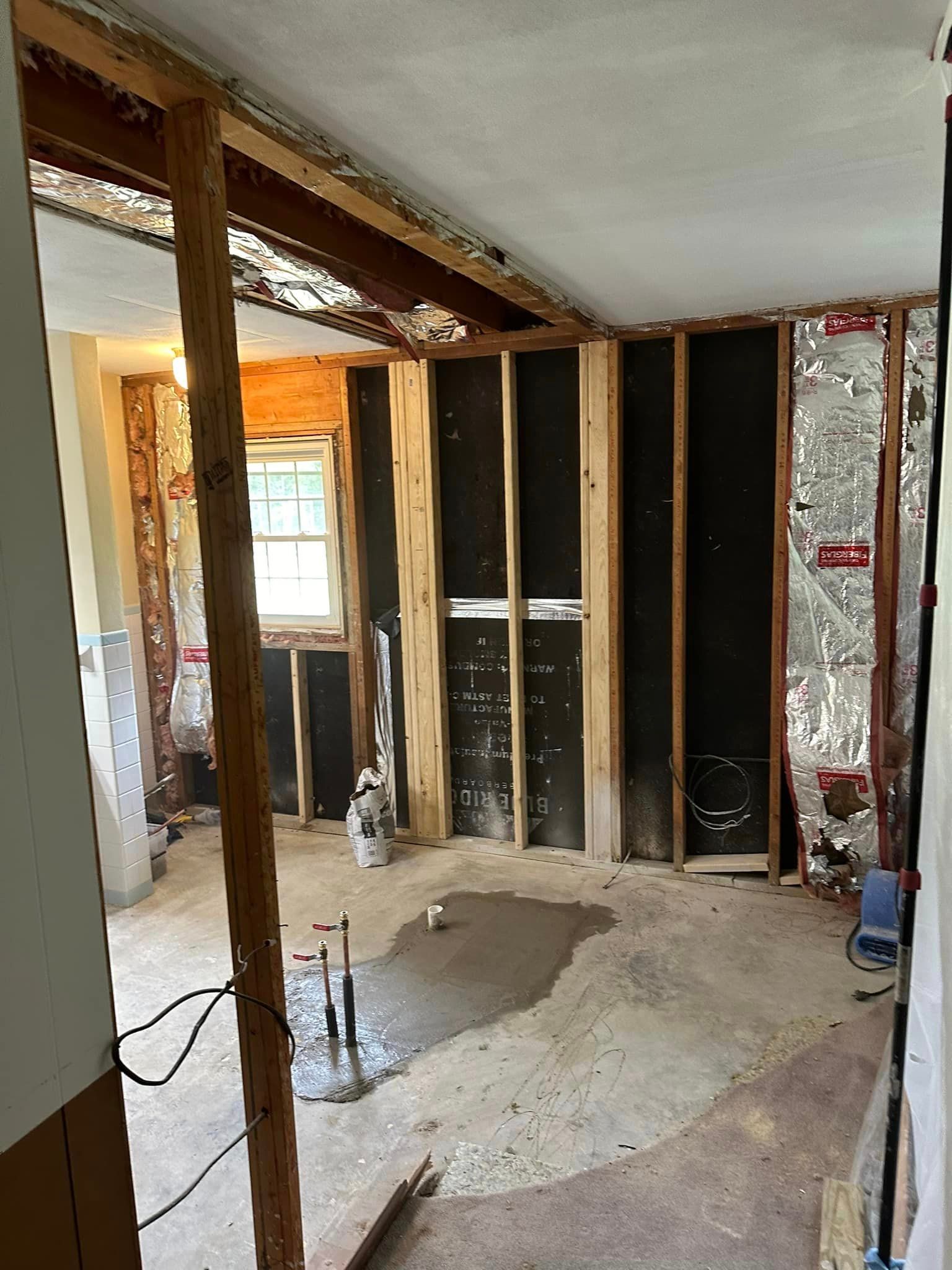 A room that is being remodeled with wooden beams and a window.