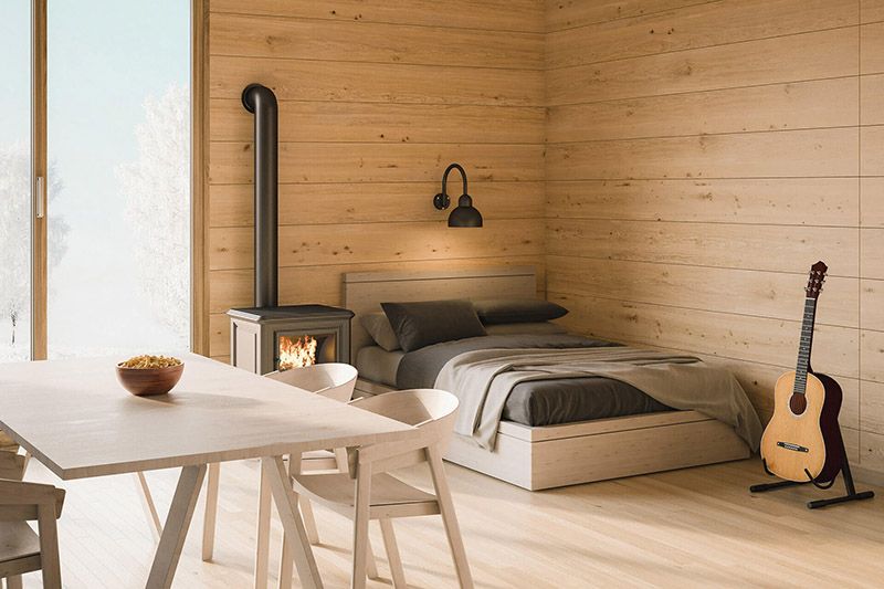 Una camera da letto con letto, tavolo, sedie e chitarra.