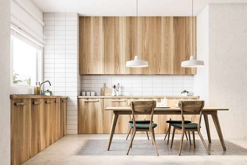 Una cucina con mobili in legno e tavolo da pranzo e sedie.