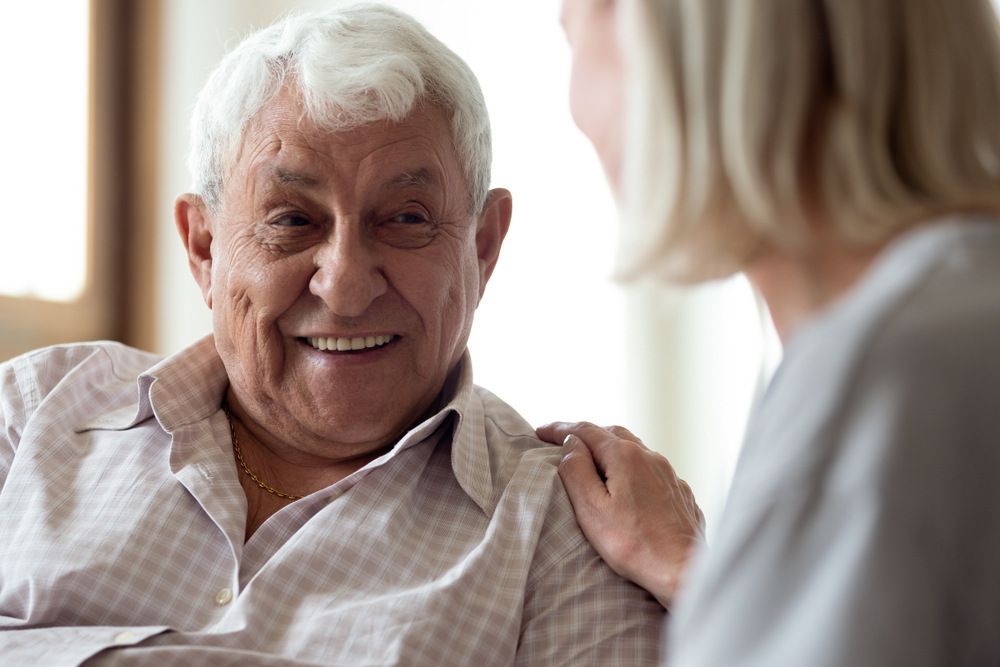 An Elderly Man is Smiling While Talking to a Nurse — Universal Nurse in Toogoolawah, QLD
