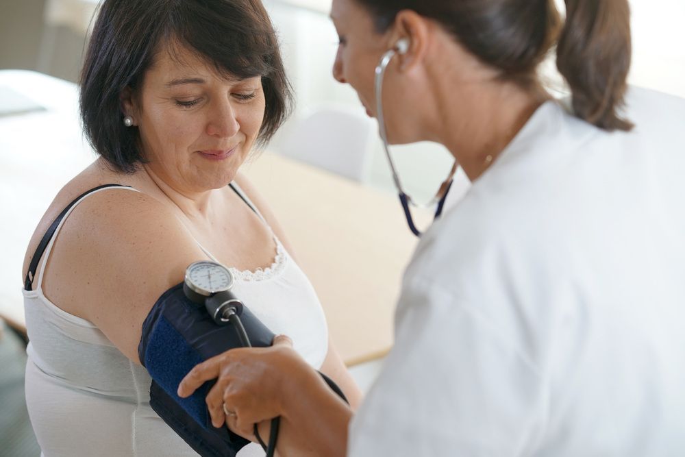 Doctor Examines a Woman During a Medical Check-up in a Clinical Setting — Universal Nurse in Blackbutt North, QLD