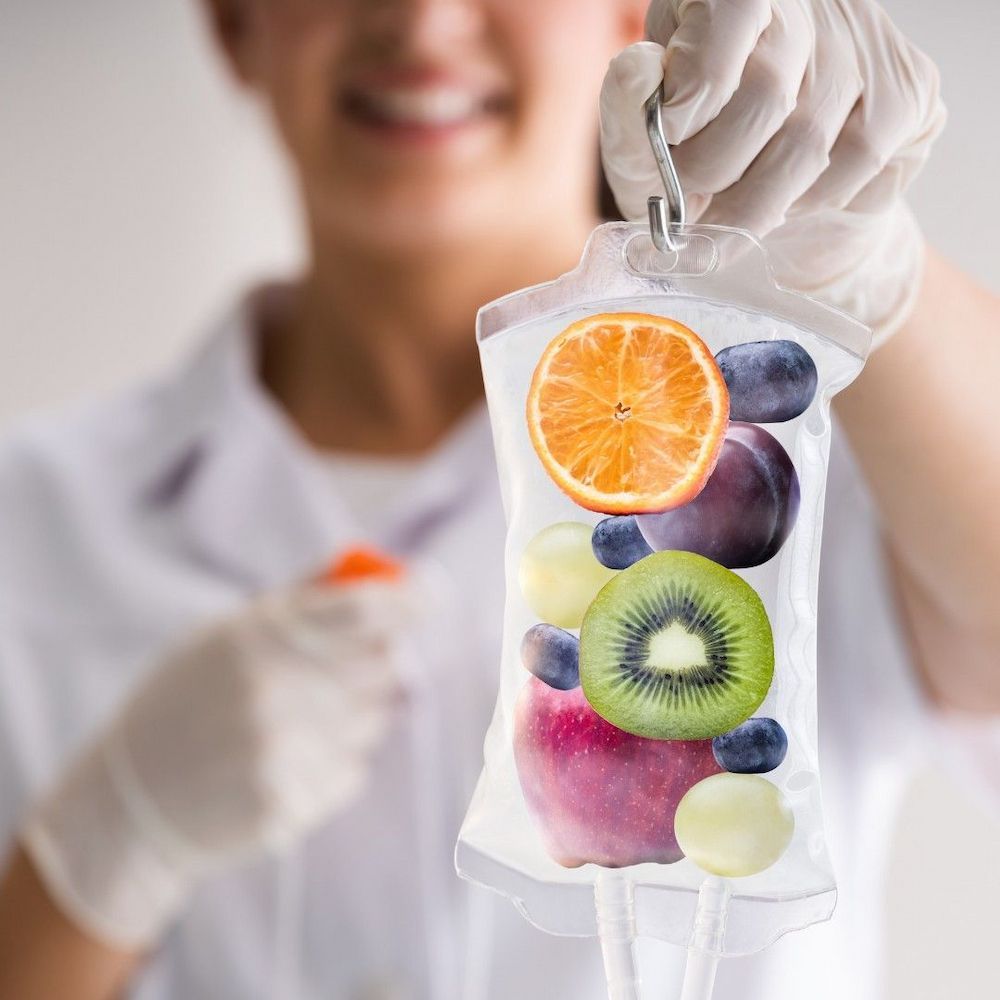 Nurse Holds IV Bag Filled With Colourful Fruit — Universal Nurse in Blackbutt North, QLD