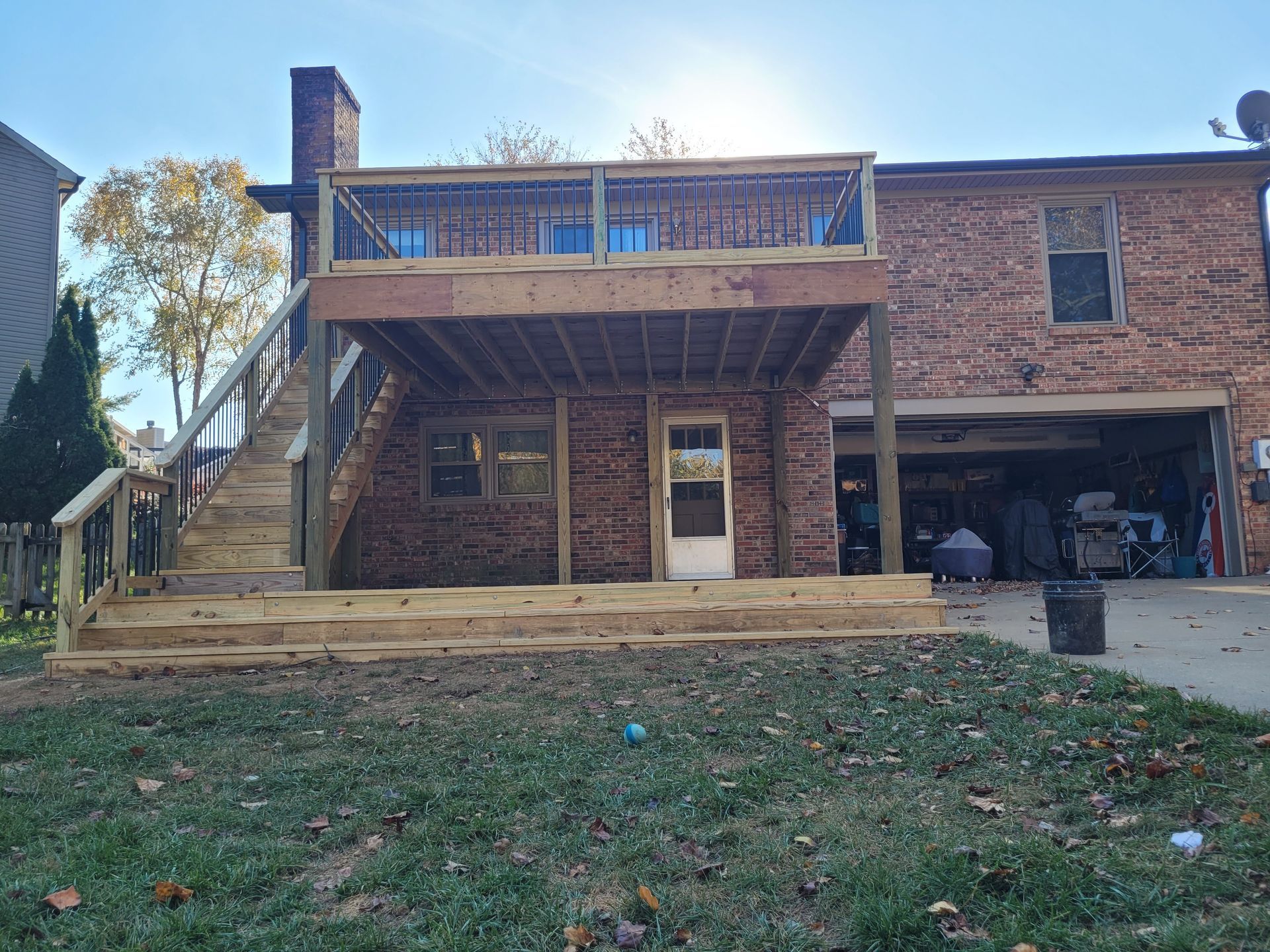 A house with a wooden deck and stairs in front of it.