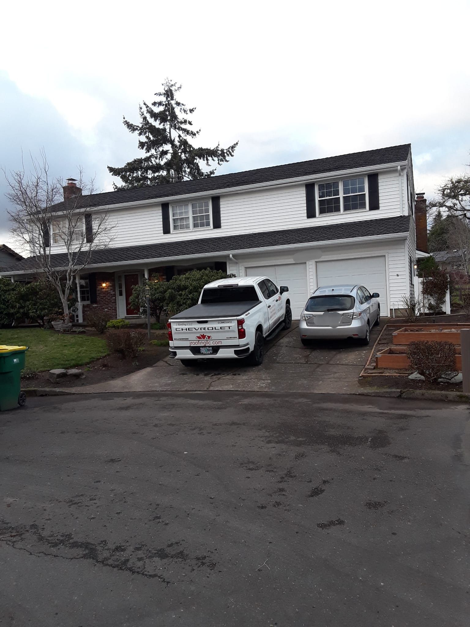 a white truck is parked in front of a white house