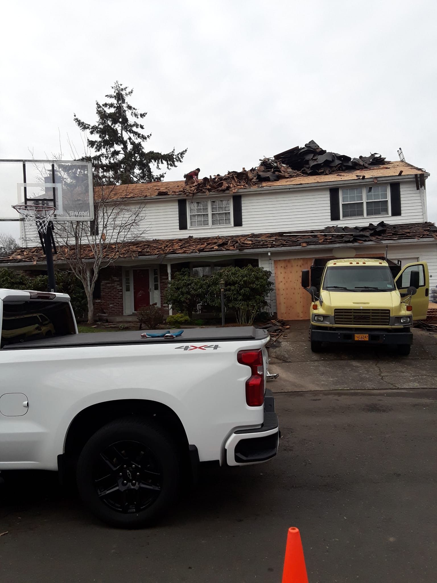 a white truck is parked in front of a house that is being remodeled .