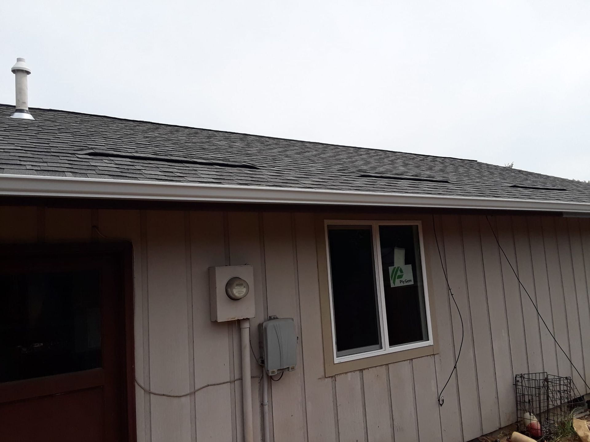 the back of a house with a roof and a window .