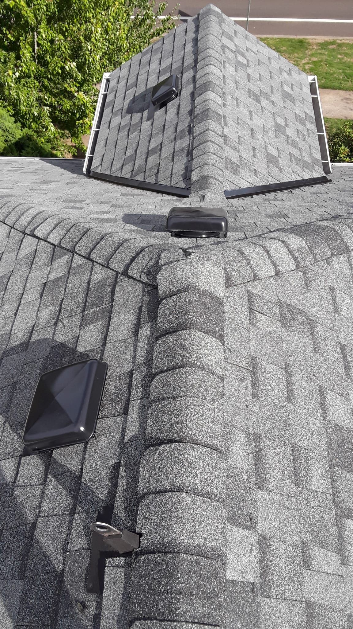 a close up of a roof with shingles and a skylight .