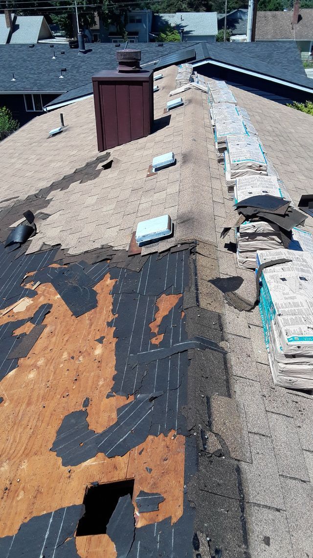 a roof that is being repaired with a chimney in the background