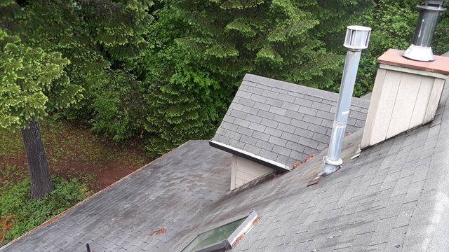 an aerial view of a roof with a chimney and a skylight .