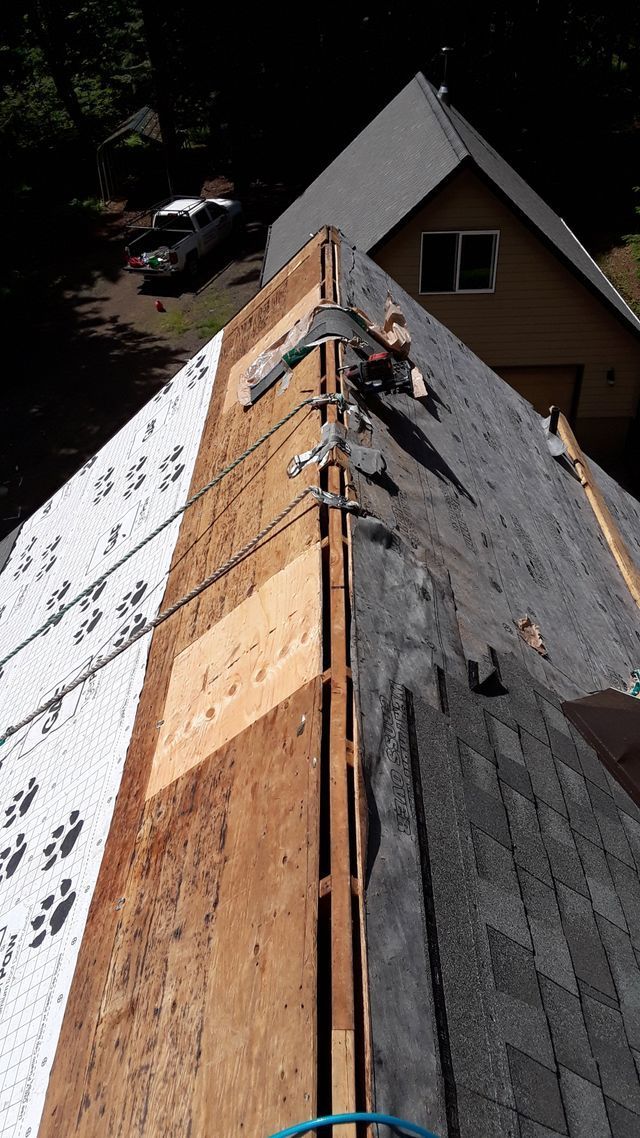 a roof with shingles being installed on it is being repaired .