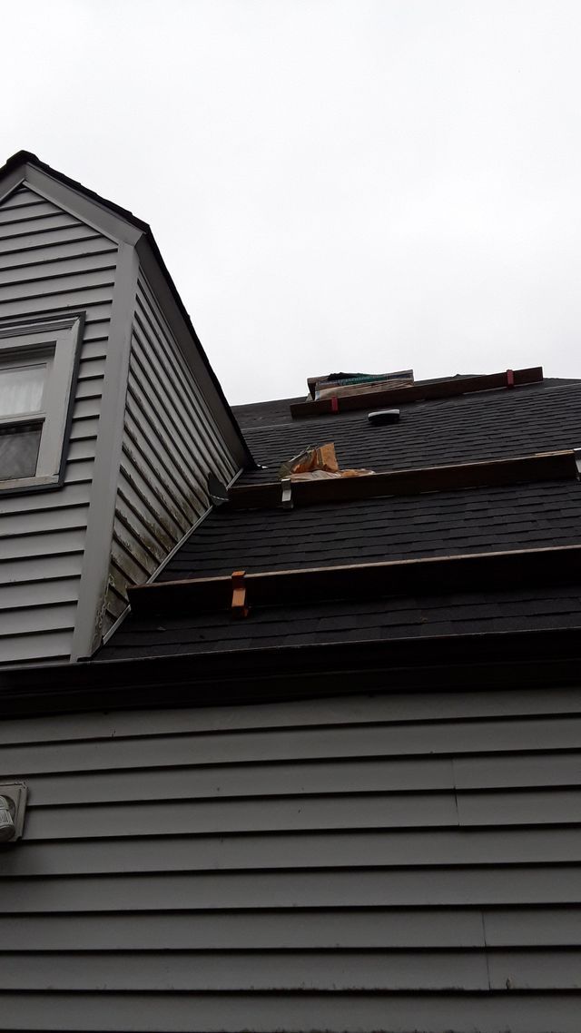 a house with a roof that has been damaged by a storm .
