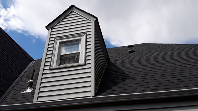 the roof of a house has a small window on it