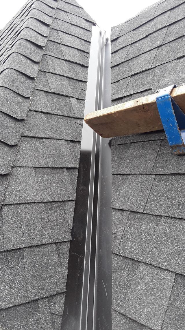 a ladder is sitting on top of a roof next to a gutter .