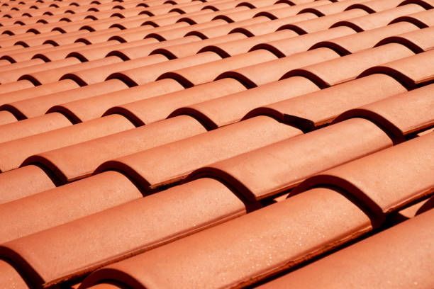 a close up of a row of red tiles on a roof