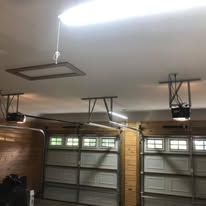 A garage with two garage doors and a ceiling fan.
