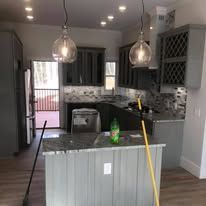A kitchen with a large island and a bottle of soda on the counter.
