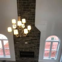 A living room with a fireplace and a chandelier hanging from the ceiling.