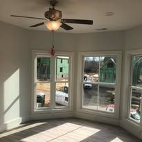 A room with a lot of windows and a ceiling fan.