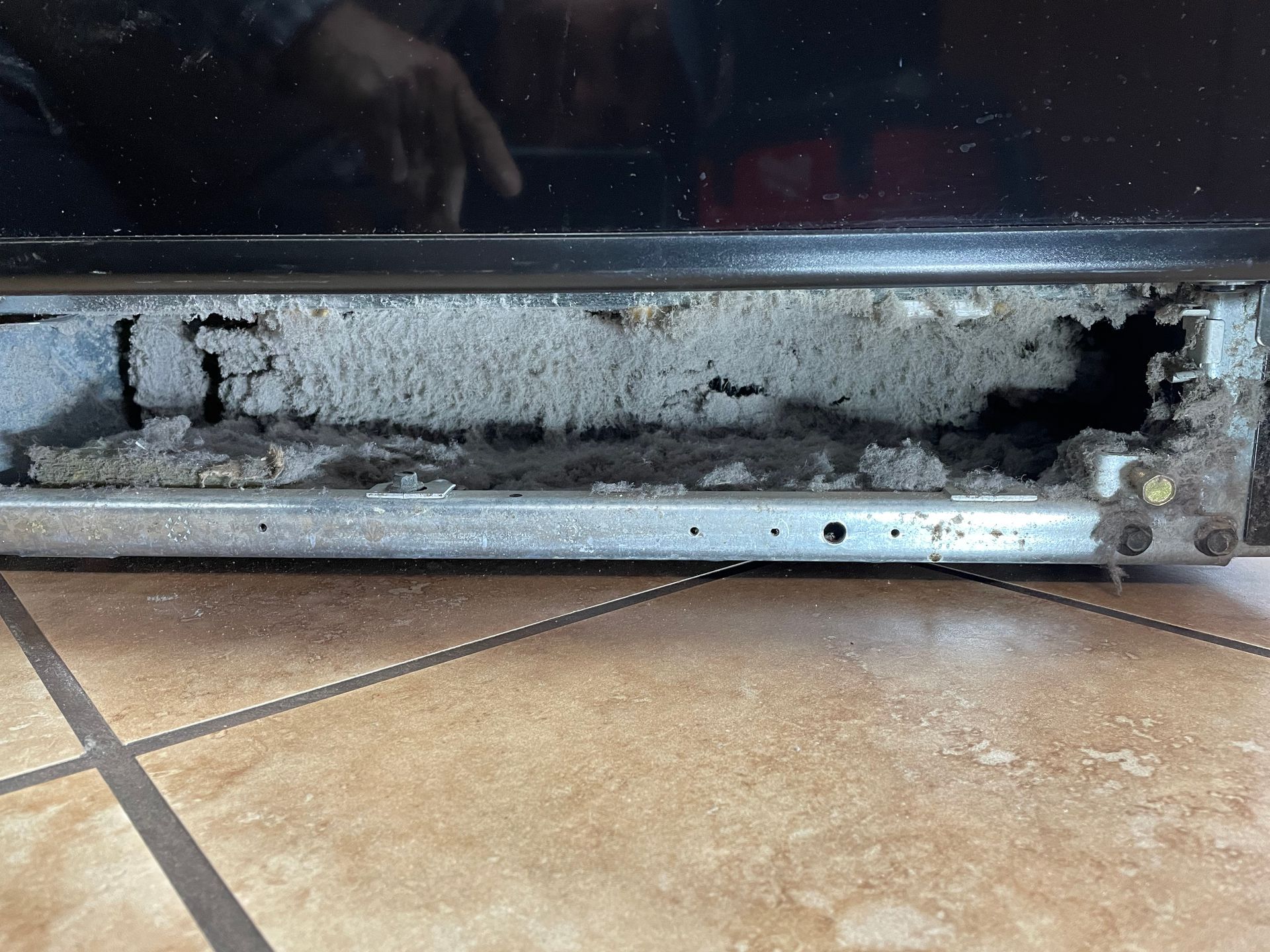 a dirty refrigerator is sitting on a tiled floor . Appliance repair Clovis