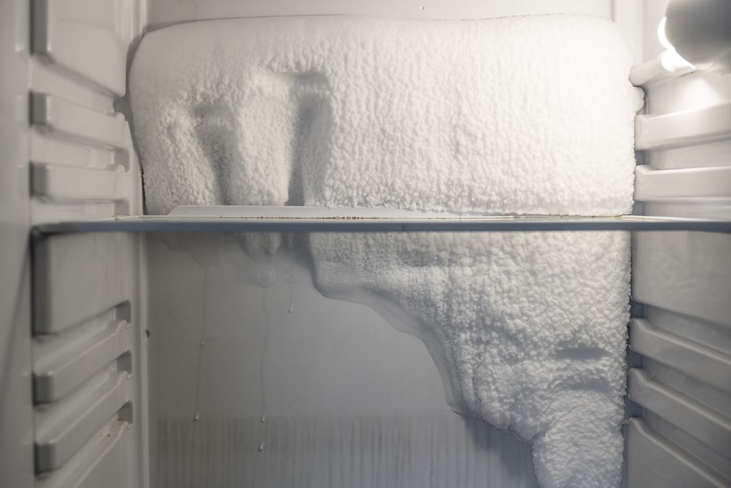 the inside of a refrigerator filled with ice and frost .