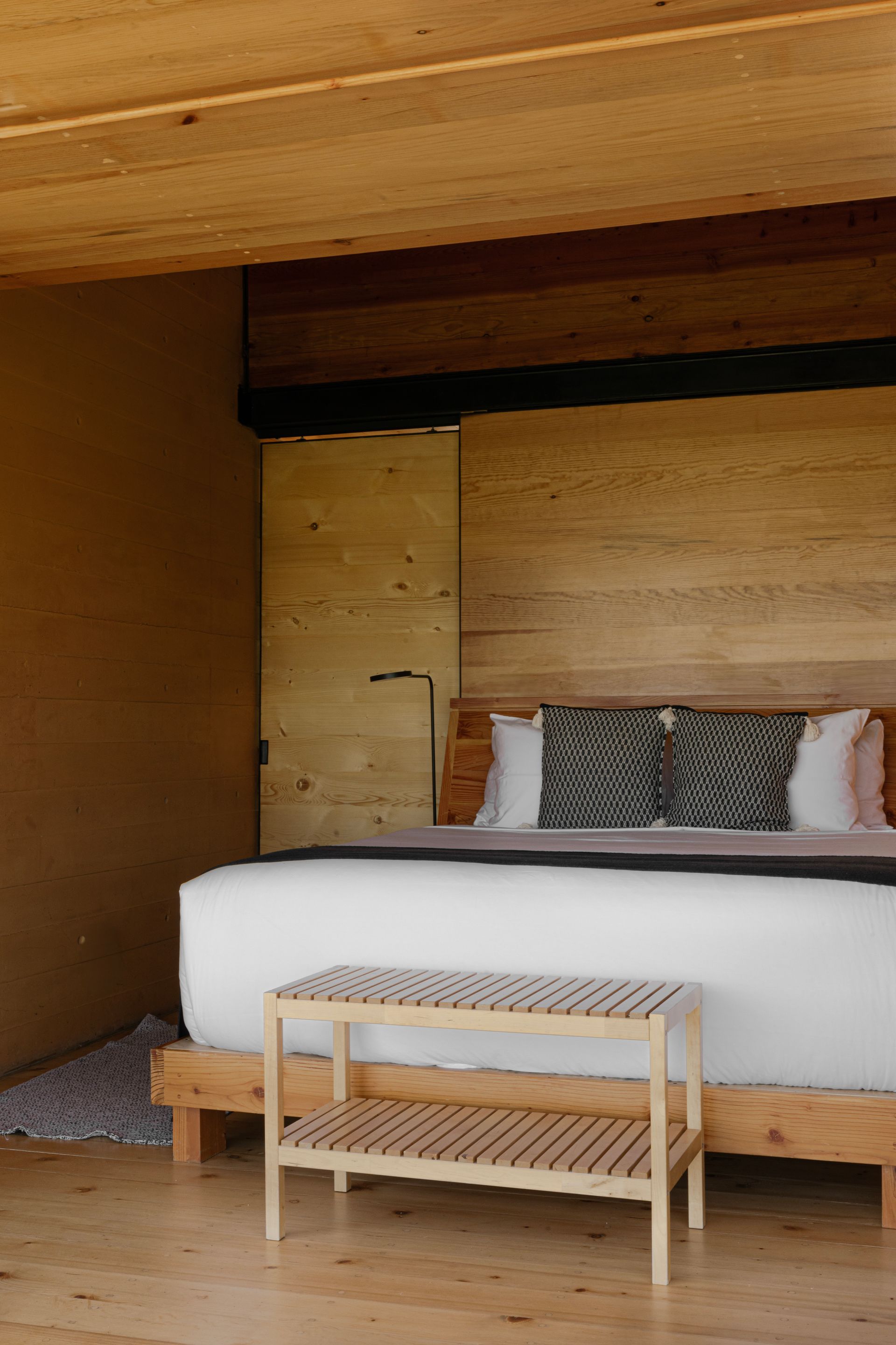 Bedroom interior with a large bed, wooden furniture, and neutral color palette.