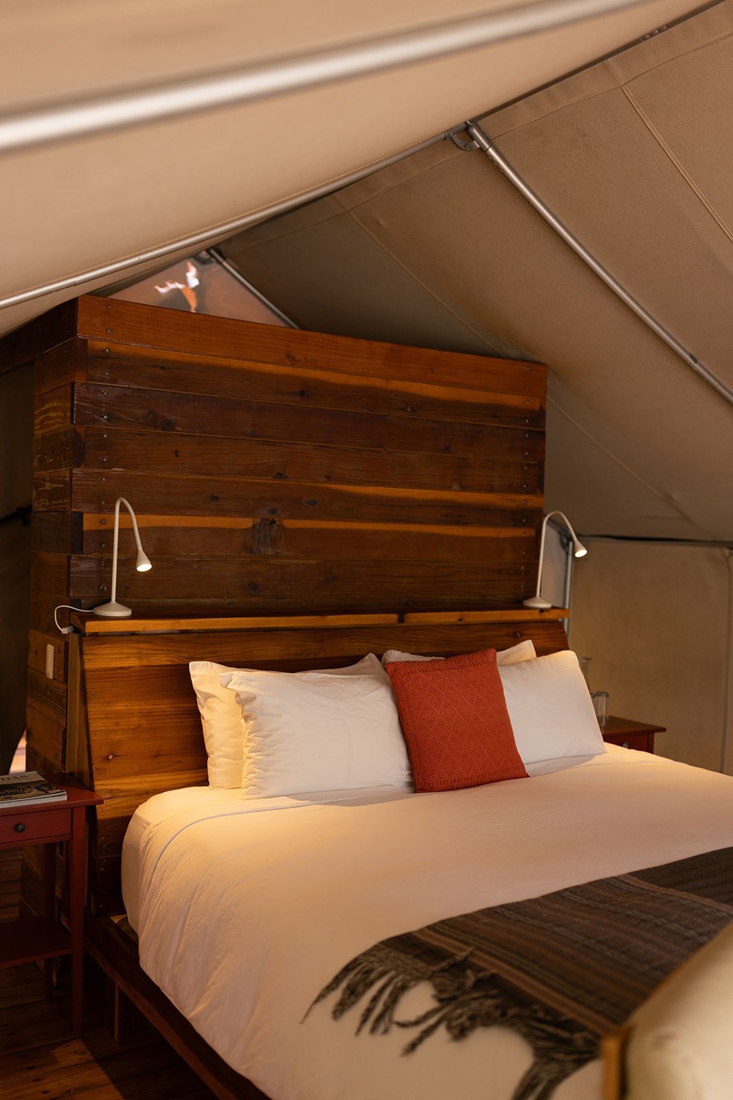 Bedroom interior with a large bed, wooden furniture, and neutral color palette.