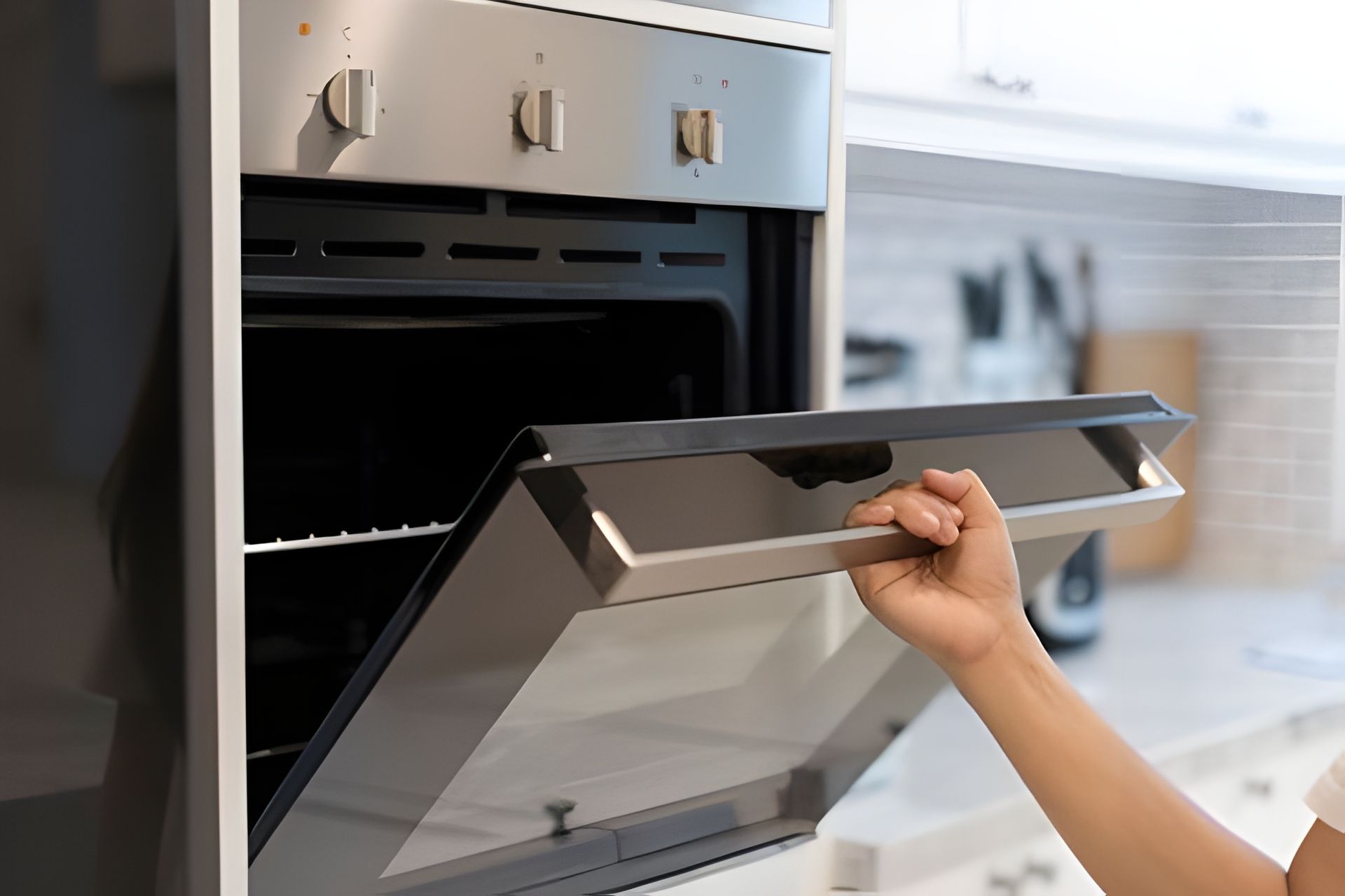A Person is Opening the door of an oven in a Kitchen — The Latest Home Appliances in Rockhampton