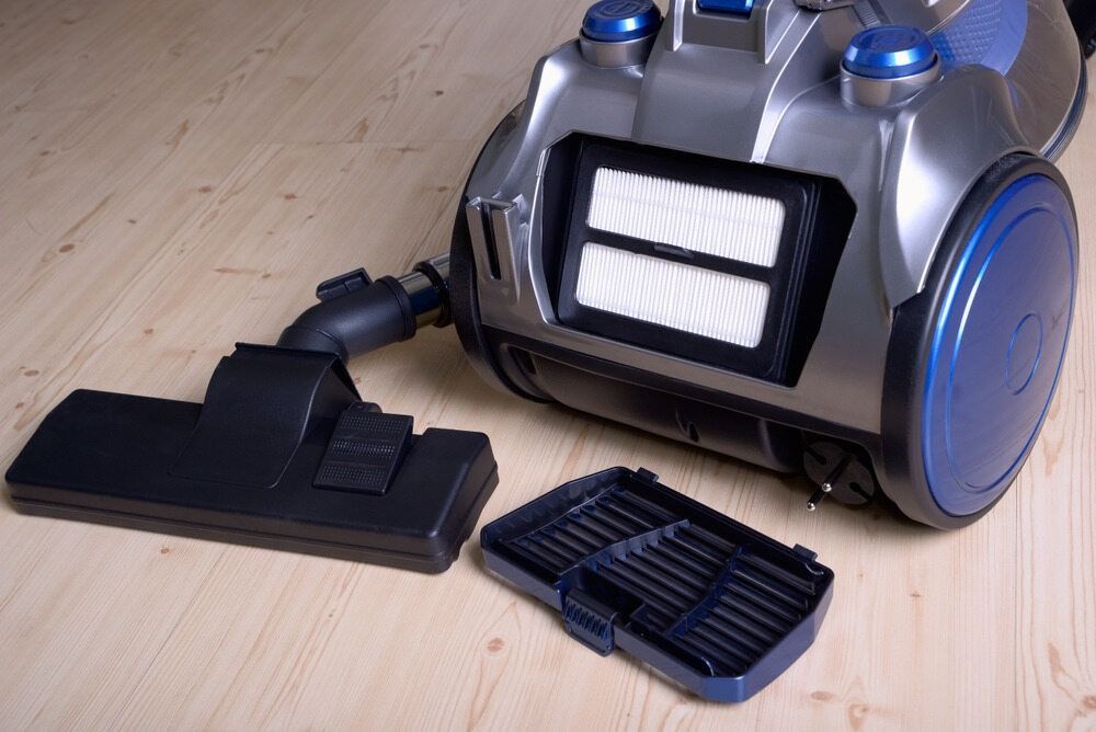 A Vacuum Cleaner with the filter Removed is Sitting on a Wooden floor — The Latest Home Appliances in Rockhampton