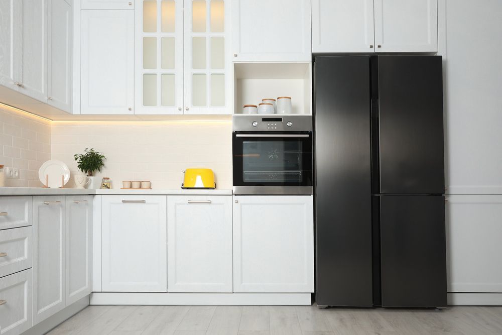 A Kitchen with White Cabinets and a black Refrigerator — The Latest Home Appliances in Rockhampton