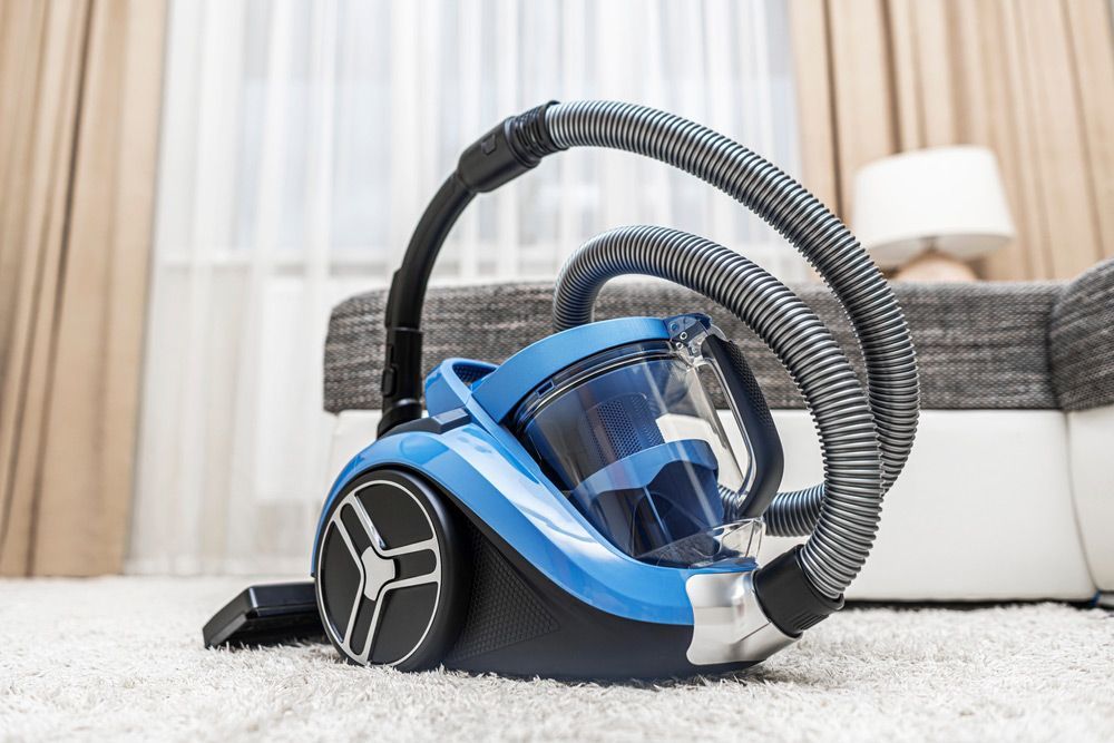 A Blue Vacuum Cleaner is Sitting on a Carpet in a Living room — The Latest Home Appliances in Rockhampton