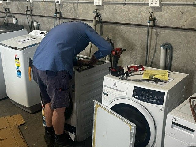 A man installing Washing Machine — The Latest Home Appliances in Rockhampton