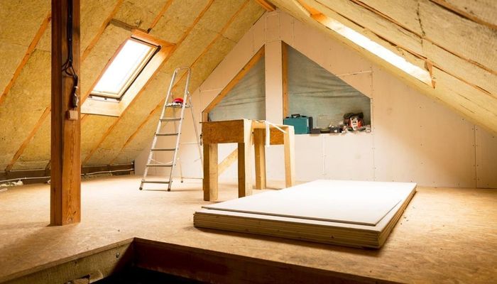 Picture of attic with natural daylight and tools and a ladder in the attic.