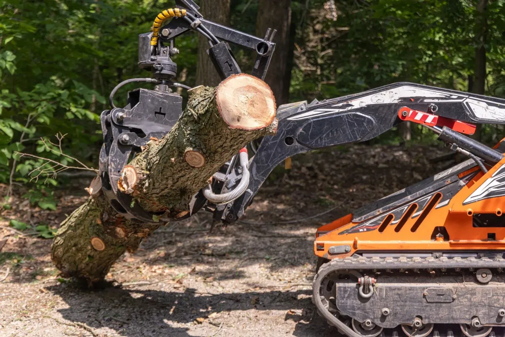 Forestry mulcher head lifting a heavy log.
