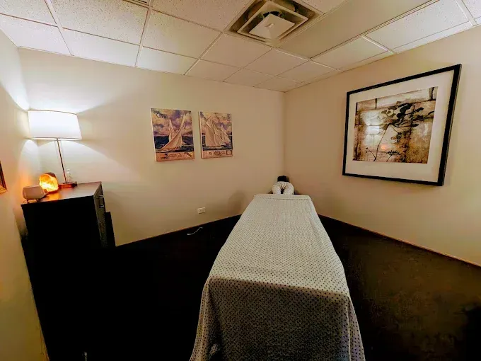 Massage room with massage table, art, and soft lighting.
