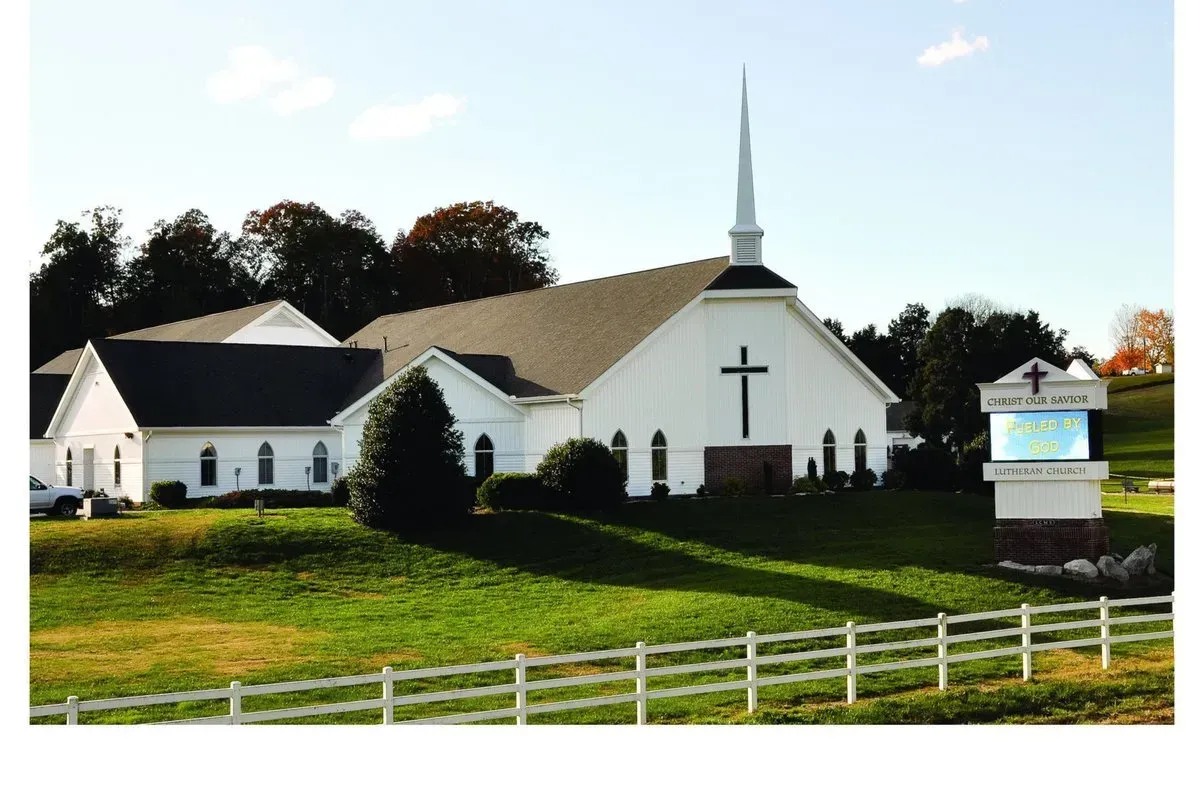 A white church with a cross on the front of it
