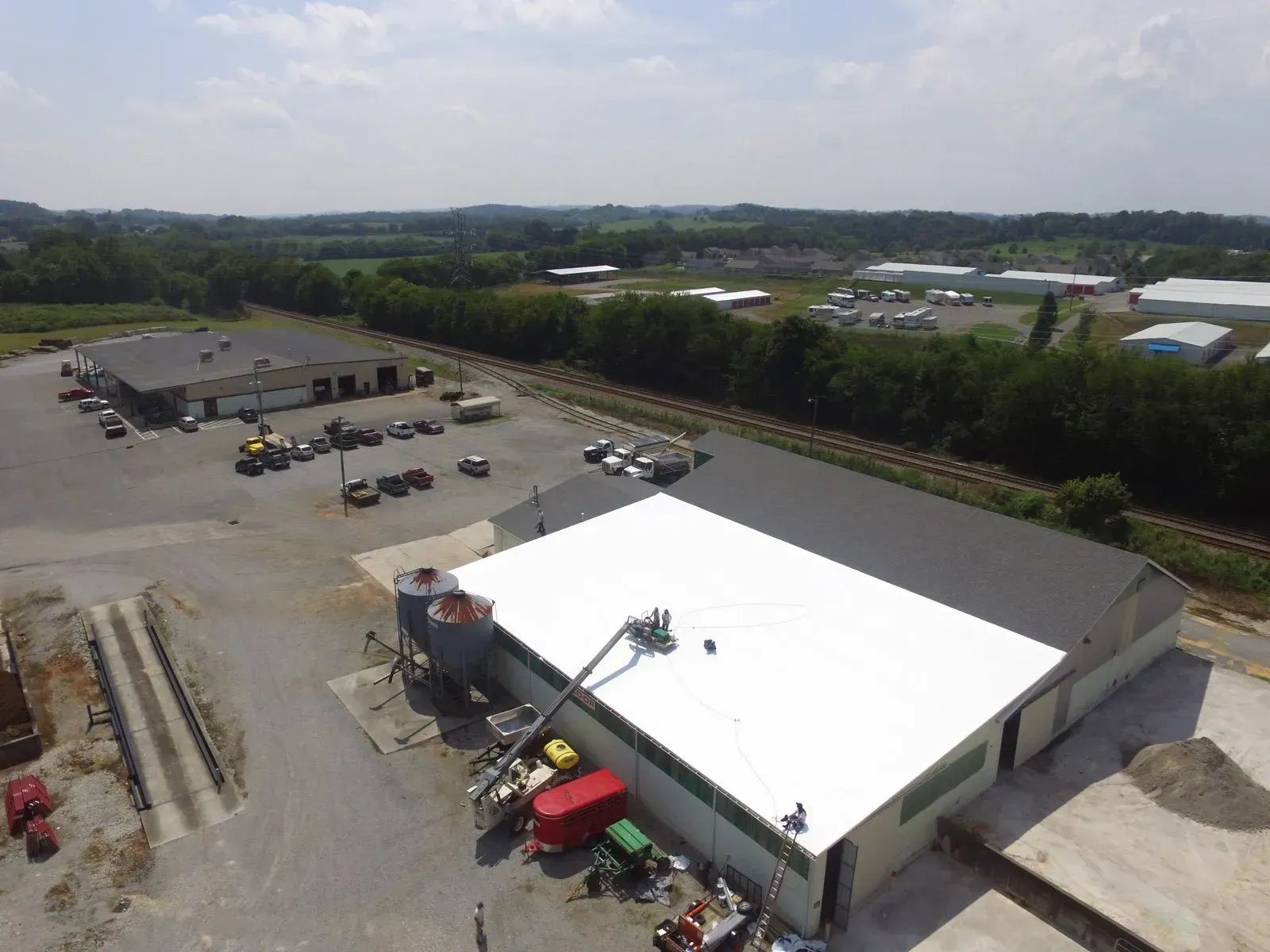 An aerial view of a large building with a white roof.