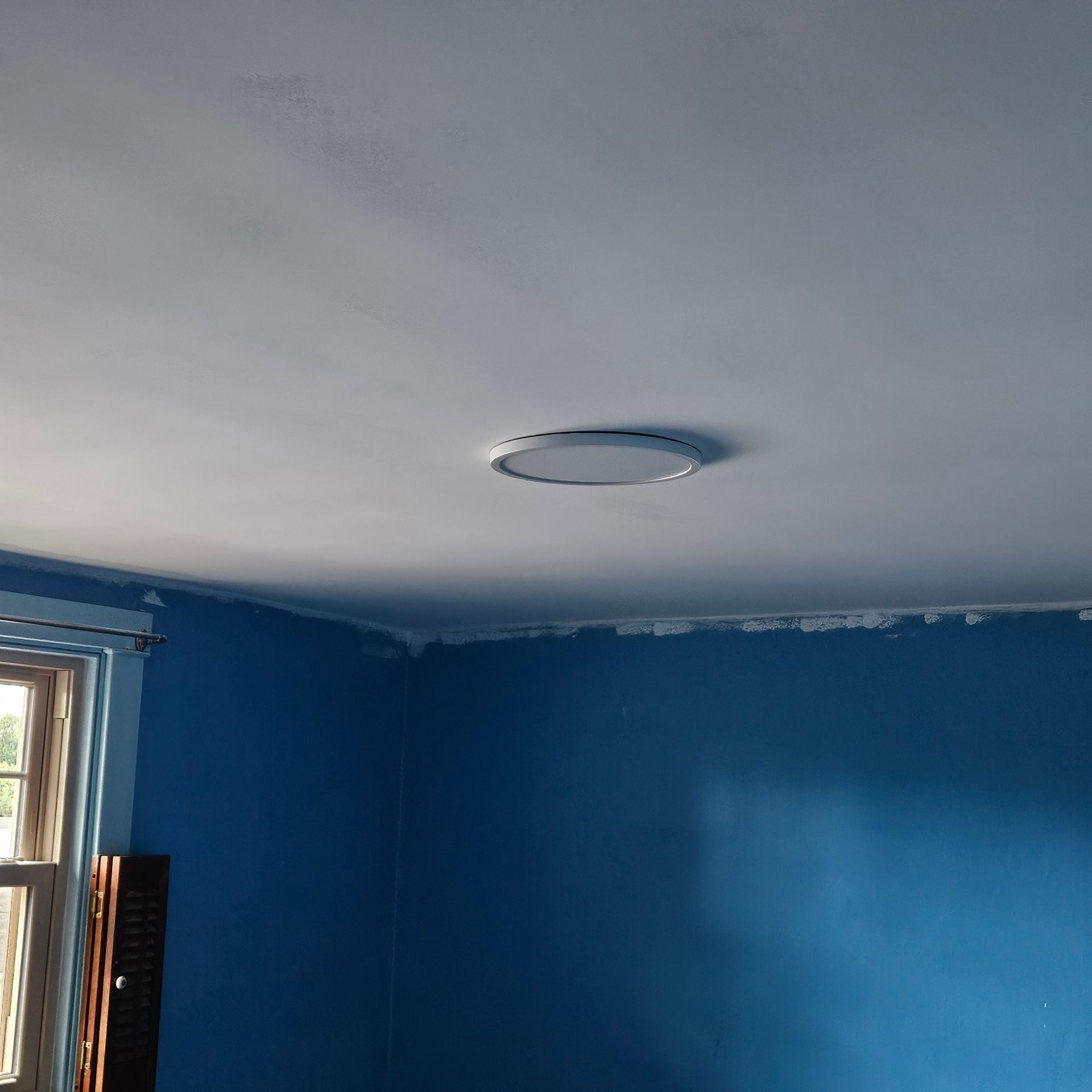 Blue room with white ceiling; a circular vent is centered on the ceiling.