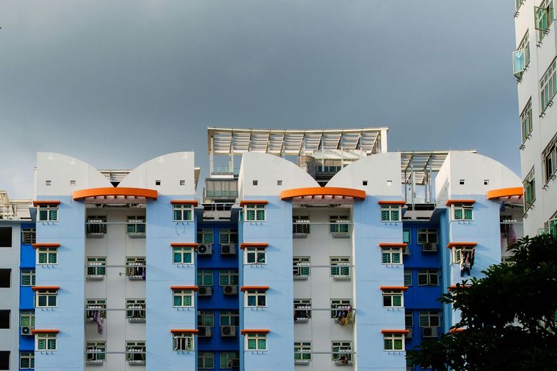 A blue and white building with a cloudy sky in the background