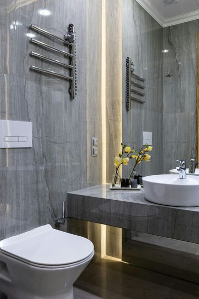 A bathroom with a toilet , sink and mirror.