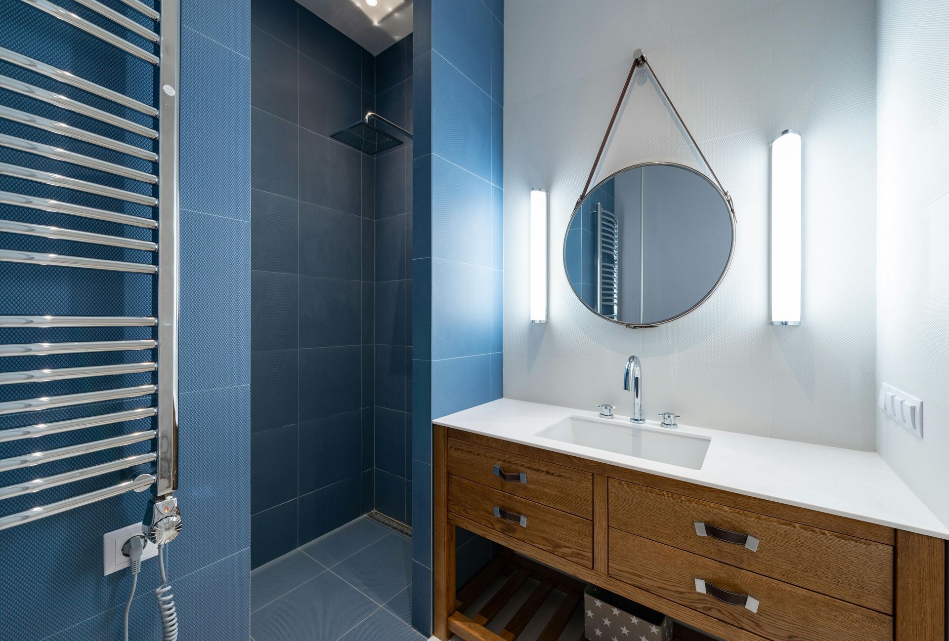 A bathroom with a sink , mirror , and walk in shower.