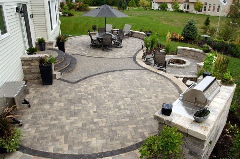 A large patio with a table and chairs and an umbrella.