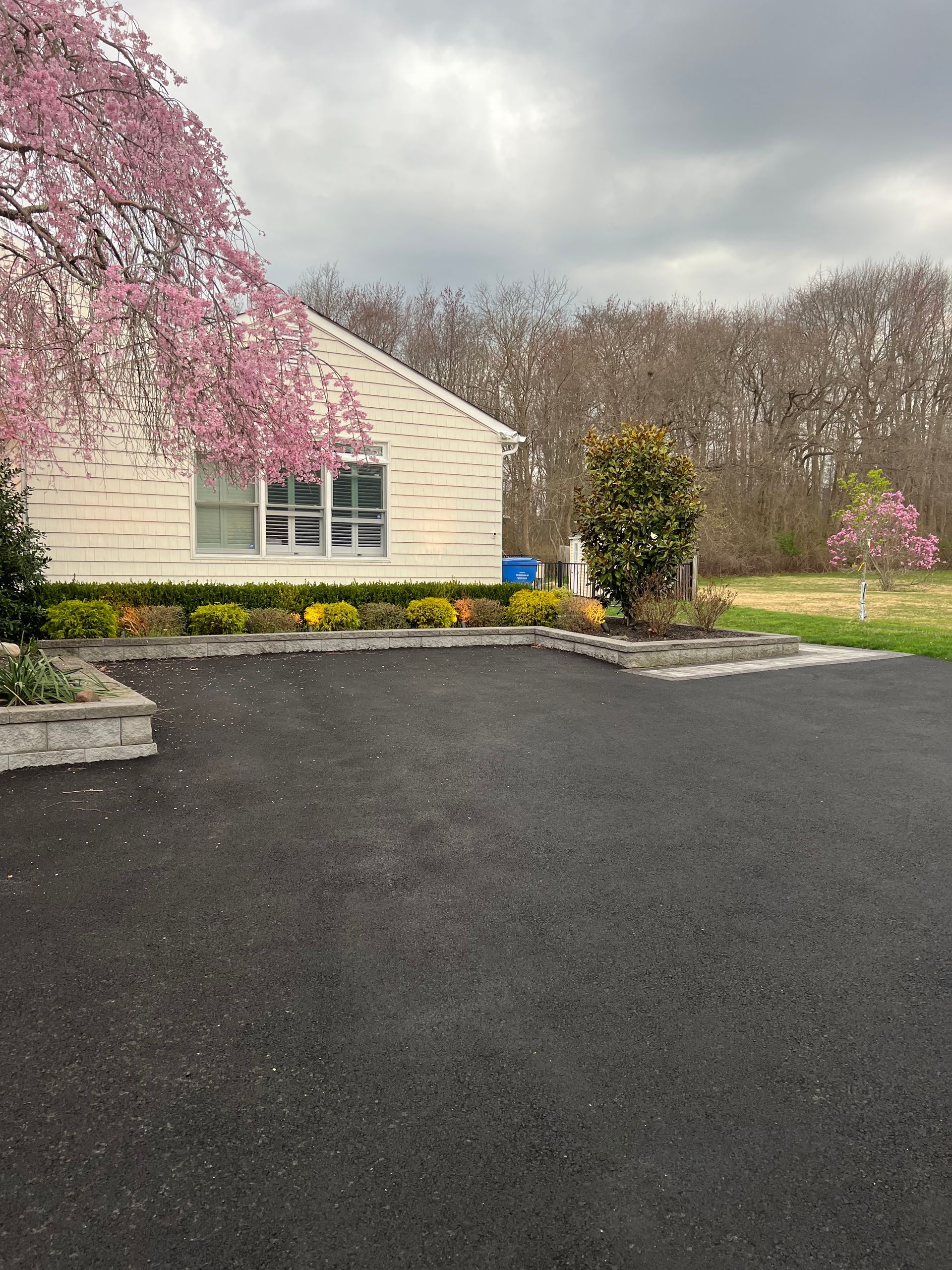 A white house with pink flowers in front of it