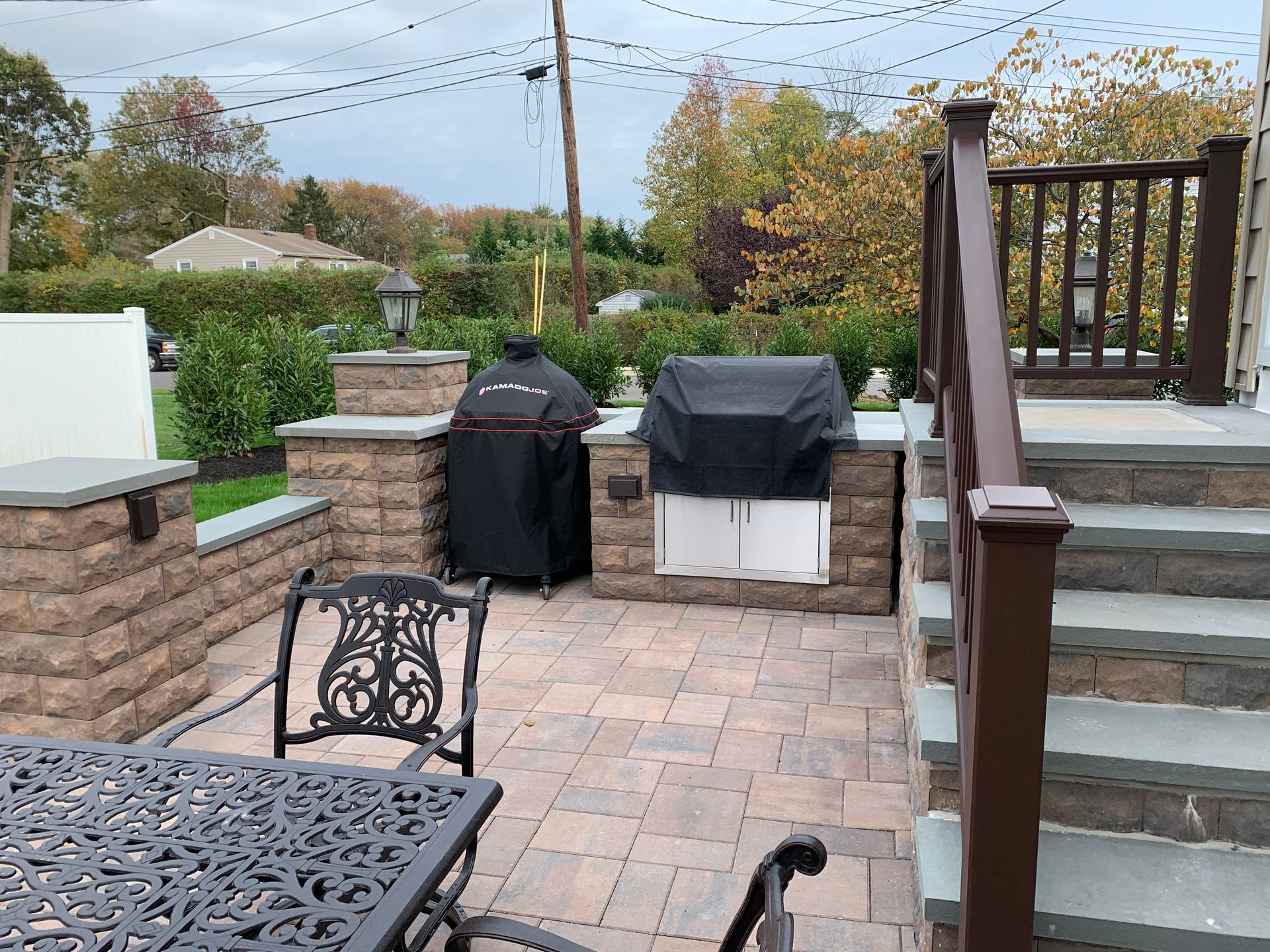 A patio with a table and chairs and a grill