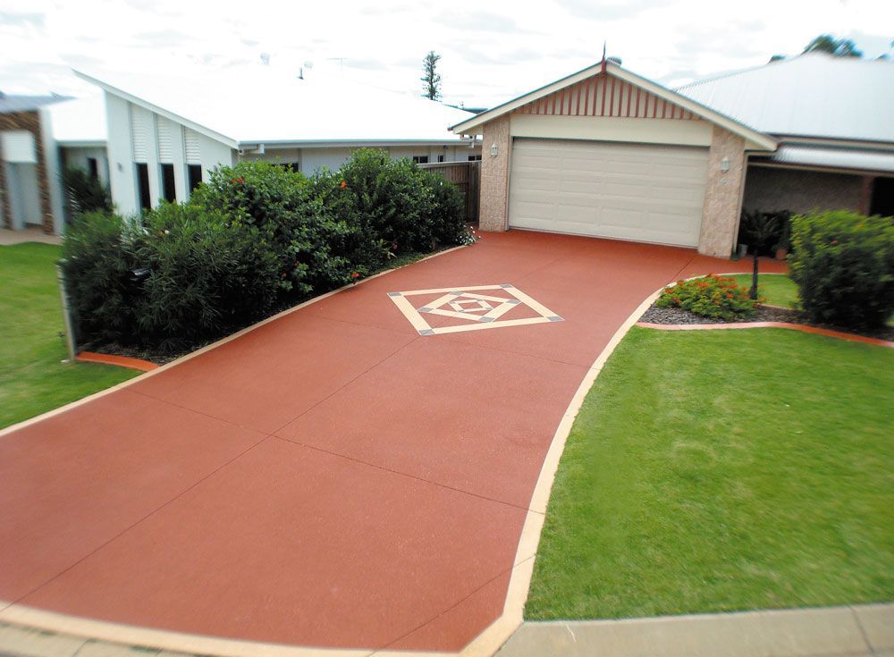 A driveway leading to a house with a square design on it