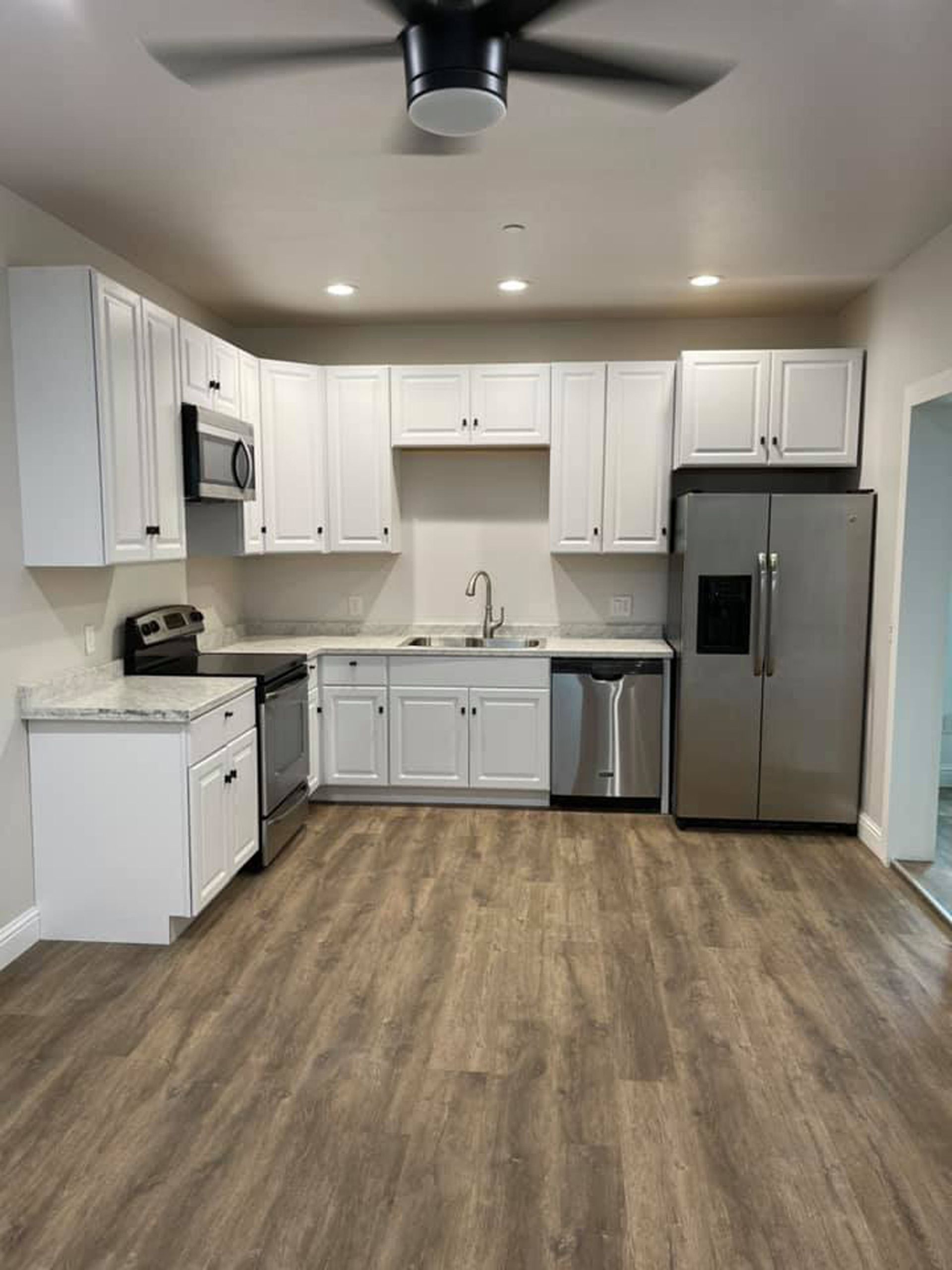 A kitchen with white cabinets and stainless steel appliances