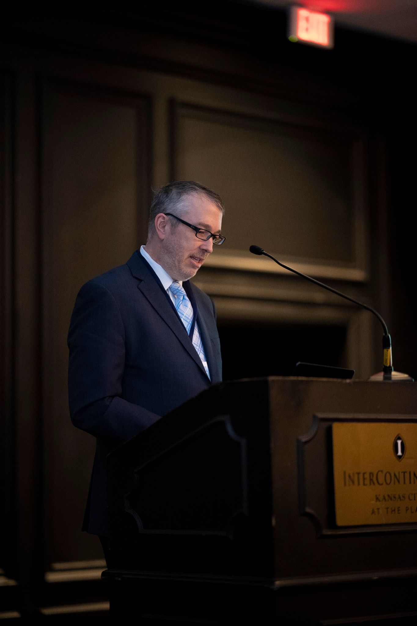 A man in a suit and tie is standing at a podium giving a speech.