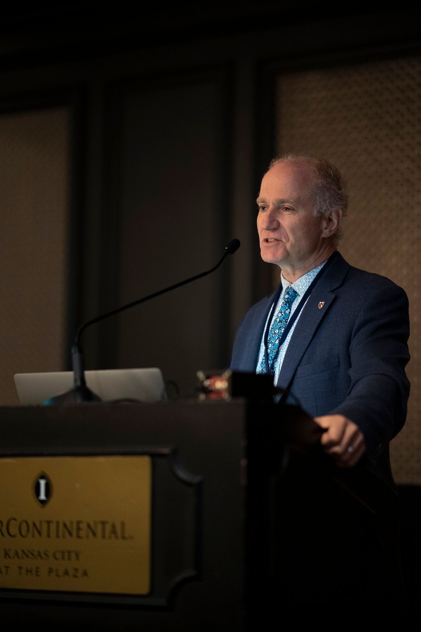 A man in a suit and tie is standing at a podium giving a speech.