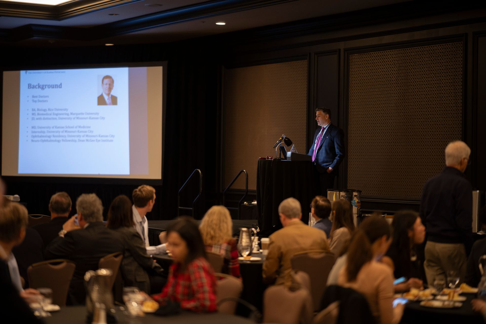 A man is giving a presentation to a group of people in a conference room.